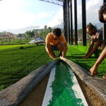 Installation of white joint tape for artificial turf during sports field construction